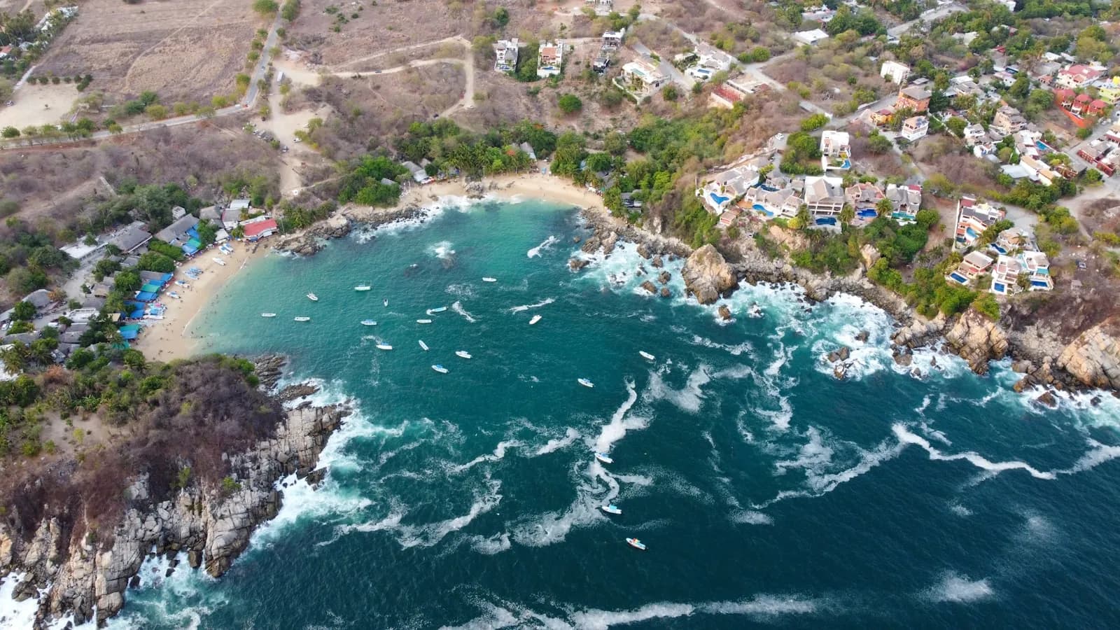 Vista aérea de una bahía de Puerto Escondido con casas en la ladera