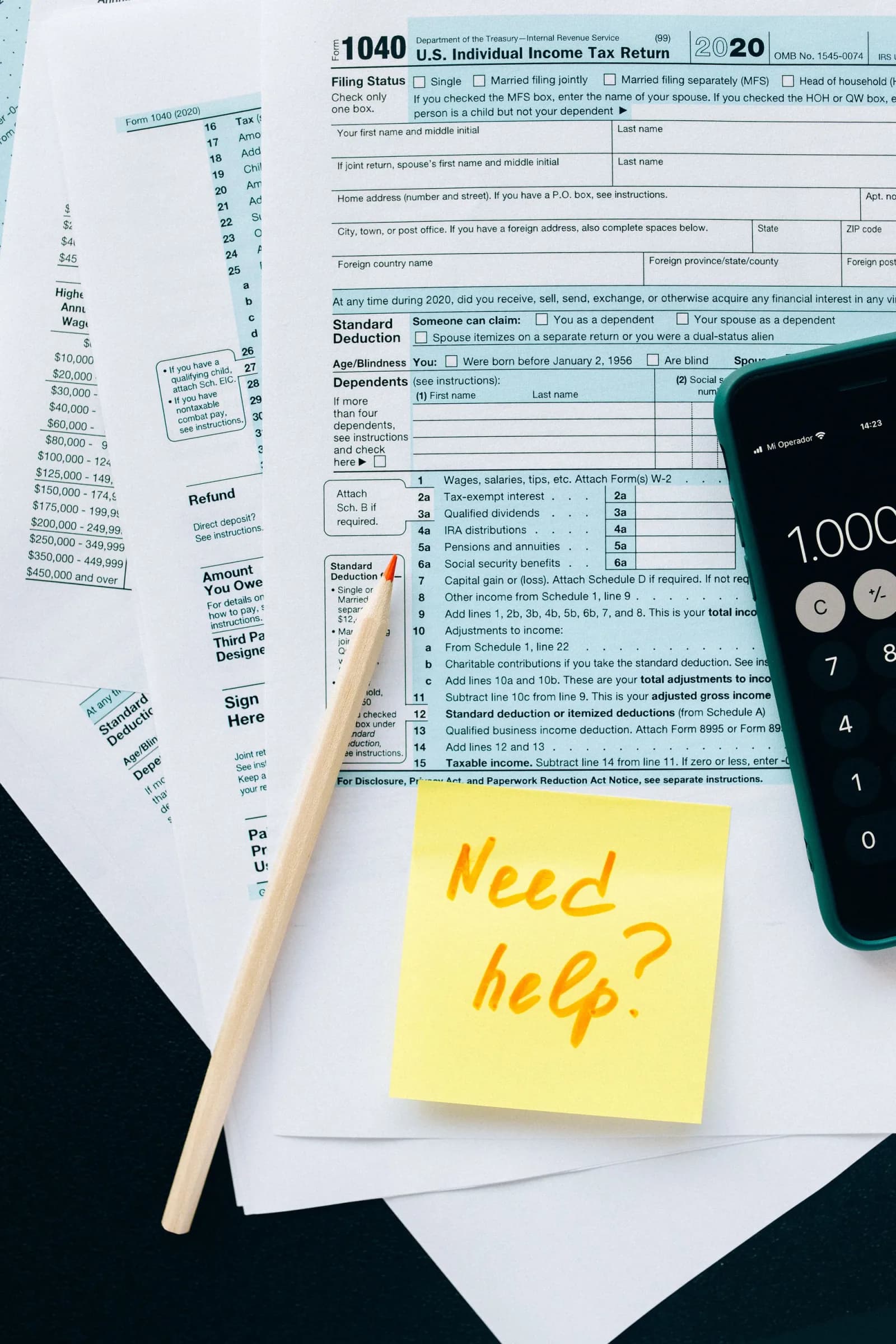 Formularios de impuestos con una calculadora, un lápiz y una nota adhesiva